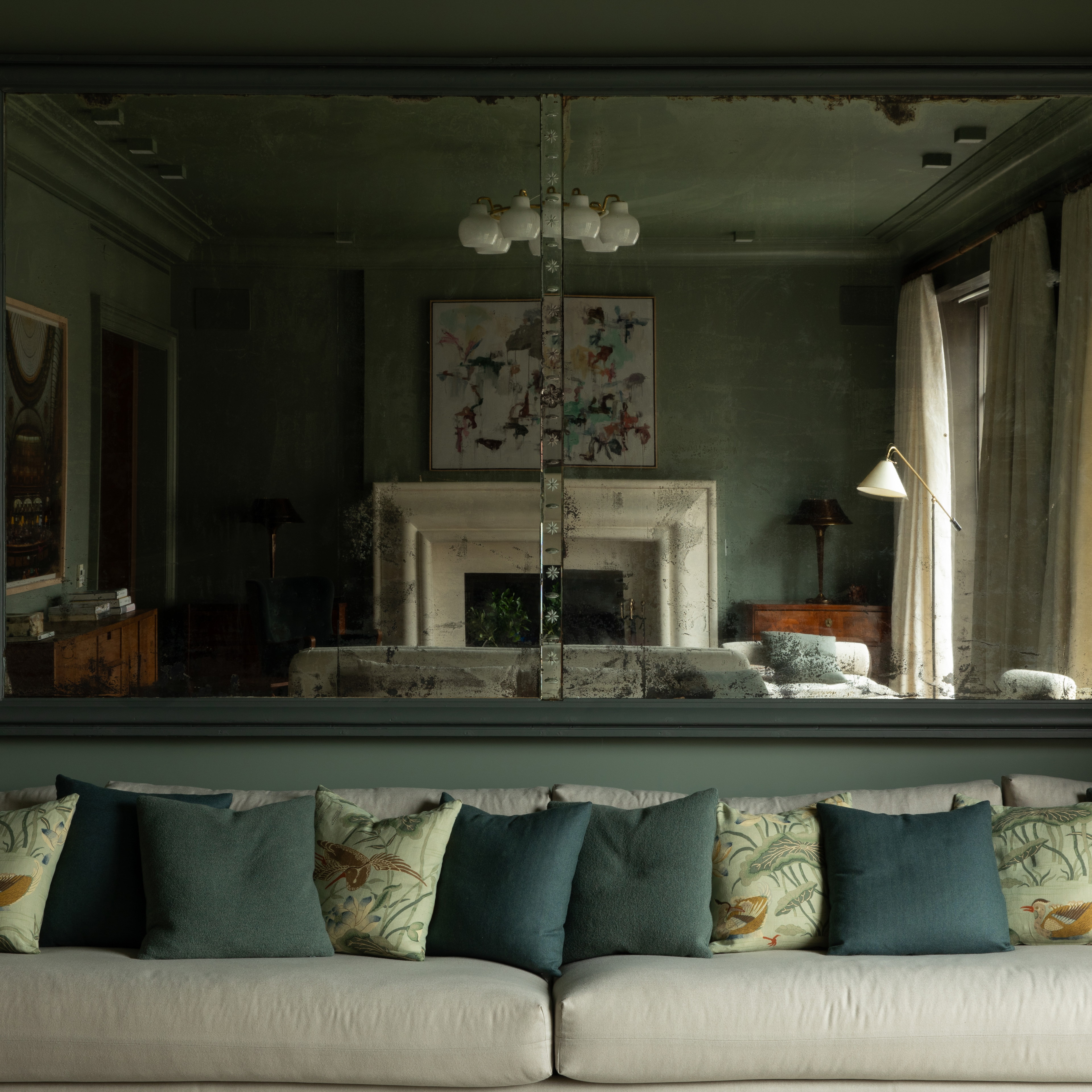 a living room filled with furniture and a large mirror