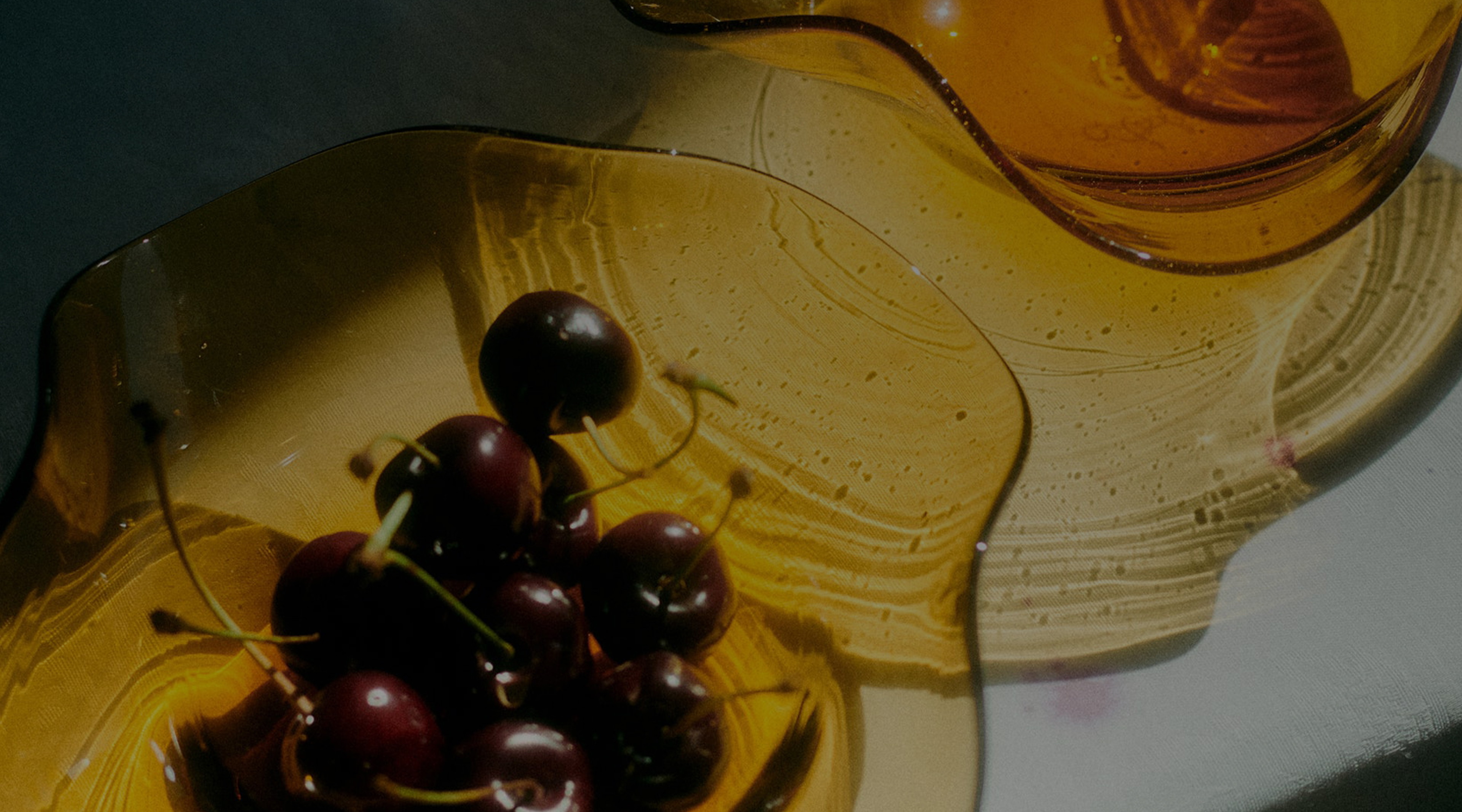 a bowl of cherries on a yellow plate